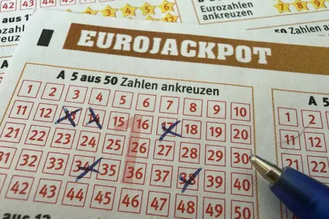 Kupon Eurojackpot z zaznaczonymi liczbami i długopisem.