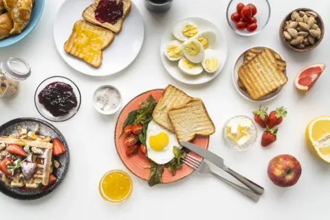 Un uovo al tegamino con pomodorini e toast, waffle con fragole, uova sode, frutta e marmellata: una colazione salata sana e gustosa.