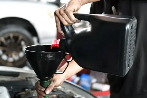 Mechanik wylewa olej do silnika. Czy lepszy będzie 5w30 czy 5w40?