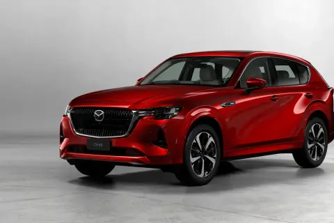 Elegancka, czerwona Mazda CX-60 3.3 Diesel prezentuje swoje dynamiczne linie na tle jasnego studia.