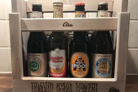 Drewniana skrzynka z butelkami piwa, w tym piwo klasyczne polskie. Na skrzynce napis "BAD CH PAH".