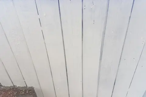 Vitmålad träpanel som takfot, redo för ett nytt lager färg.