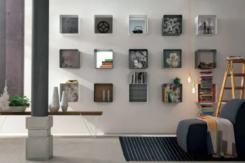 Moderna parete con mensole quadrate, alcune decorate, altre contenenti libri e oggetti, per arredare con stile.
