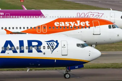Samoloty linii Ryanair i easyJet stojące obok siebie na płycie lotniska.