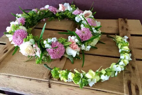 Två midsommarkransar med rosa och vita blommor, perfekta för midsommar naglar.