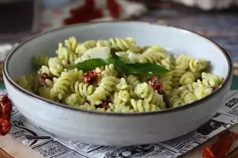 Fusilli conditi con un cremoso pesto di zucchine, arricchiti da pomodori secchi, pinoli e basilico fresco. Un piatto estivo e saporito.