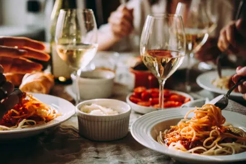 En härlig middag med spaghetti och tomatsås, perfekt som middagstips vardag. Glas med vitt vin och bröd kompletterar måltiden.