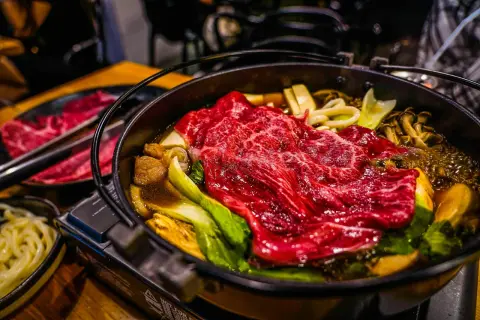 Ein dampfender Hot Pot Japan mit zartem Rindfleisch, Pilzen und Gemüse.