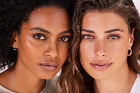 Dos mujeres de pieles y cabellos distintos, con miradas serenas, celebrando la belleza pro aging.