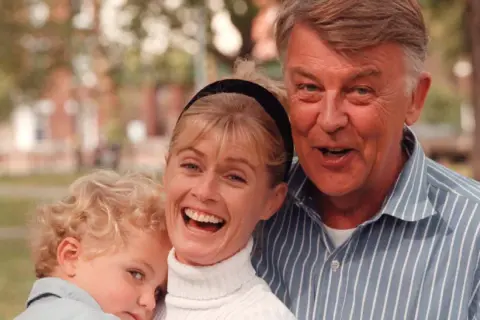 Glad familj med ett barn, en kvinna och en man. Kanske är det Felix Taube med sin familj.