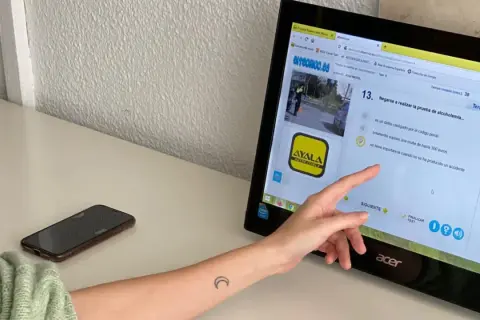 Persona haciendo un test de conducir teórico en un ordenador. La pregunta es sobre negarse a la prueba de alcoholemia.