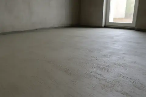 Świeżo wylana posadzka betonowa, gotowa na kolejne etapy budowy. Zastanawiasz się, ile worków cementu na palecie?