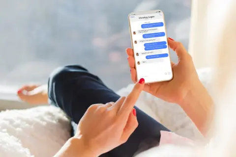Dłoń trzyma smartfon z rozmową na Messengerze. Można tu zobaczyć, jak być niewidocznym na Messengerze, ale widzieć innych, gdy ekran pokazuje status "online" u rozmówcy.