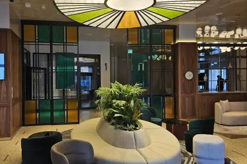Nowoczesne wnętrze z designerską sofą i roślinnością. Kolorowe witraże i okrągły plafon tworzą niepowtarzalny klimat w grand hotelu Wrocław.