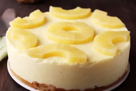 Deliciosa tarta de piña, cremosa y decorada con rodajas y trozos de piña fresca. ¡Un postre tropical irresistible!