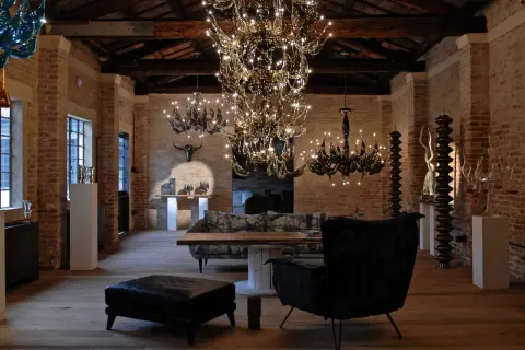 Interno con lampadari di cristallo e arredi moderni. Un'opera di Fabio Fornasier illumina l'ambiente.