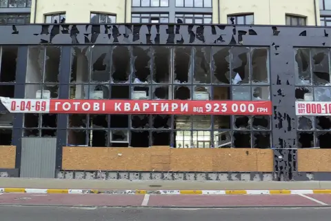 Uszkodzony budynek z banerem "GOTOWI KWARTRYRY від 923 000 ГРН". Zastanawiasz się, ile kosztuje mieszkanie na Ukrainie?