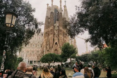 Tłum ludzi podziwia Sagrada Familia. Zastanawiasz się, ile się leci do Barcelony, by zobaczyć to cudo architektury?