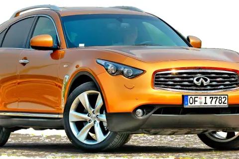 Pomarańczowy infiniti samochód z chromowanymi detalami i felgami.