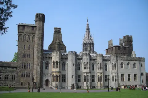 Zamek w Cardiff, stolicy Walii, z imponującą architekturą i zielonym trawnikiem.
