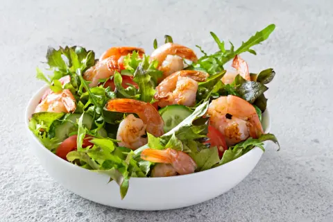 Salade de crevettes fraîche et colorée, garnie de légumes croquants et de tomates juteuses.