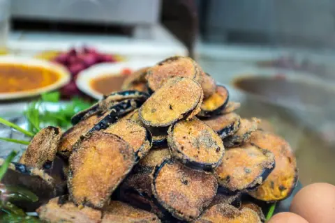 Un tas de beignets d'aubergine dorés et croustillants, prêts à être dégustés.
