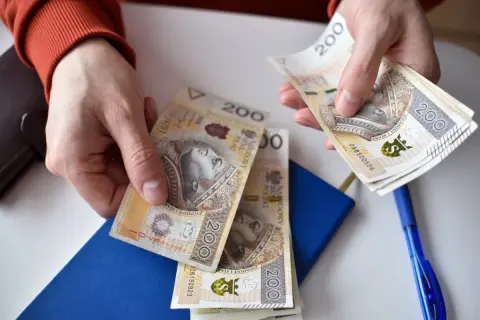 Ręce liczą banknoty 200 zł. Ile godzin nocnych w miesiącu można za nie opłacić?