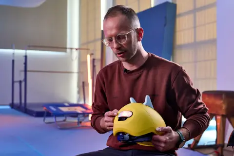 Mann erklärt, wie muss ein Fahrradhelm sitzen: Kinderhelm mit Ohren, gut angepasst und sicher.