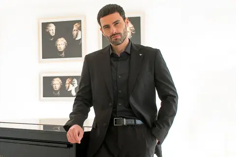 Uomo con abito nero, camicia e cravatta abbinati. Eleganza senza tempo.