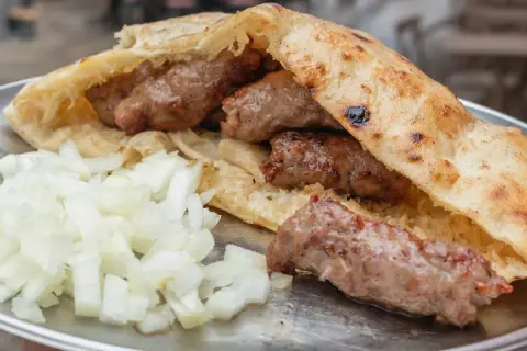Pyszne cevapcici w bułce, jak u Makłowicza, z dużą ilością cebulki.