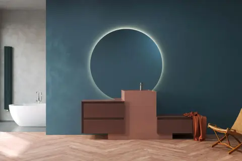 Mobile bagno moderno con lavabo integrato in materiale corian, specchio circolare retroilluminato e finiture in legno.