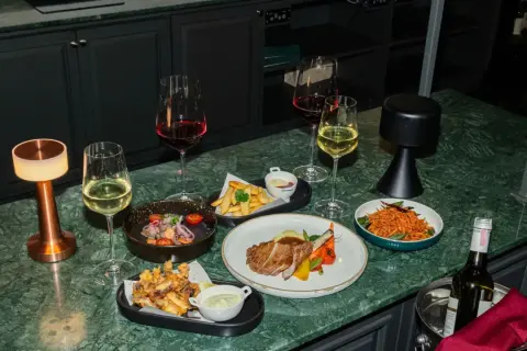 Elegancka kolacja z kieliszkiem chardonnay wino, stekiem, frytkami i sałatką.
