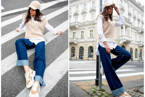 Elegancka stylizacja: jak nosić kamizelkę damską. Modelka w beżowej kamizelce, białej koszuli i jeansach na tle miasta.