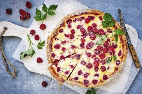 En härlig hallonpaj, perfekt för ett somrigt hallonpaj recept. Garnerad med färska hallon och myntablad.