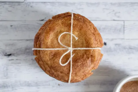 Un paquete de galletas con azúcar y canela, atadas con hilo rústico, listas para compartir.
