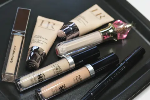 Korektor pod oczy ranking: kolekcja kosmetyków do makijażu, w tym Givenchy, Make Up For Ever i Marc Jacobs, gotowa do ukrycia cieni.