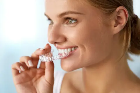 Donna sorridente mostra il suo invisalign indossato, un sorriso smagliante in arrivo.