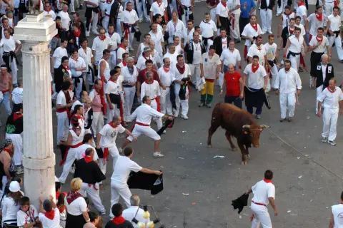 Multitud en el programa fiestas Teruel, con un toro bravo y gente vestida de blanco y rojo.