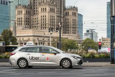 Srebrny samochód Uber na tle warszawskich wieżowców. Czy to Twój pierwszy raz z Uberem?