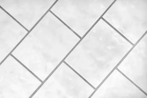 Białe, błyszczące płytki ułożone w geometryczny wzór. Precyzyjna rektyfikacja płytek zapewnia idealnie równe fugi.