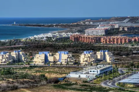 Edificios modernos y el mar azul en Almerimar, Almería. Un paisaje costero con arquitectura contemporánea y la brisa marina.