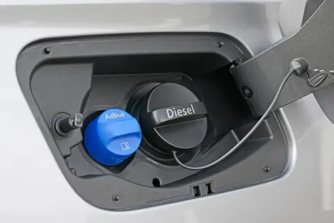 Tapa azul de AdBlue junto a la de Diesel. El AdBlue es un líquido que reduce emisiones en coches diésel.