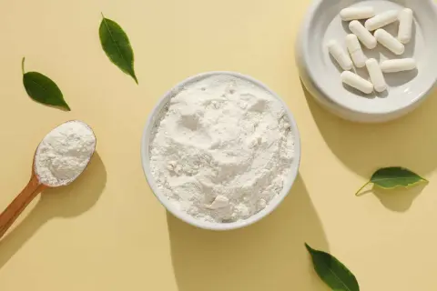 Schale mit kollagenpulver, Löffel und Kapseln. Kollagenpulver sinnvoll für Haut und Gelenke.