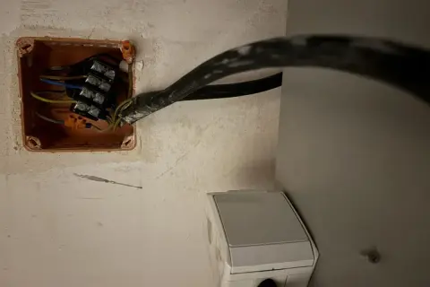 Instalacja elektryczna: jak podłączyć piekarnik bez wtyczki. Widoczne przewody w puszce instalacyjnej i gniazdko.