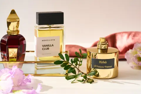 Eleganckie flakony edp perfumy: czerwony Xerjoff, Vanilla Club Novellista i złoty Kirke Tiziana Terenzi, otoczone kwiatami i gałązką.