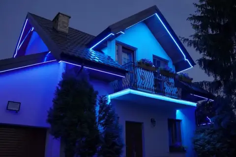 Dom oświetlony niebieską listwą RGB, podkreślającą jego architekturę.