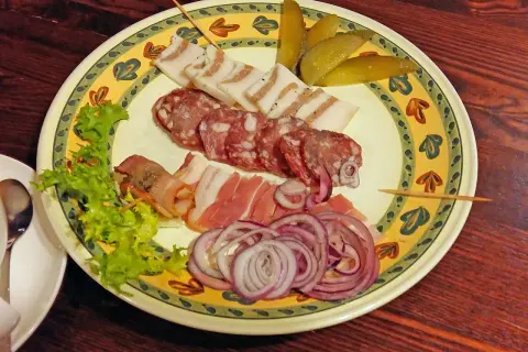 Talerz z wędlinami, słoniną, ogórkami i cebulą. Idealne danie, by dowiedzieć się, co zjeść w Wilnie.