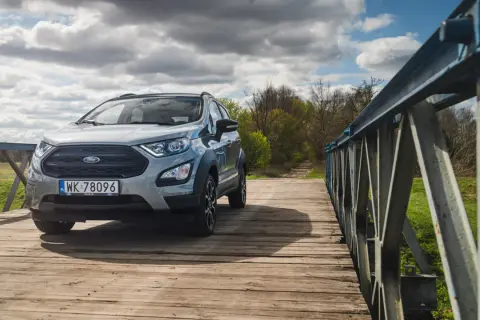 Srebrny Ford Ecosport na drewnianym moście, gotowy na przygodę.
