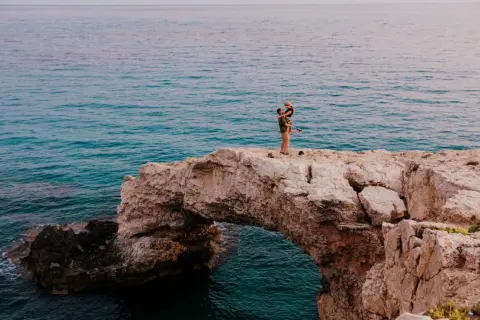 Para idealne na wakacje w listopadzie gdzie najcieplej. Para na skale nad turkusowym morzem.