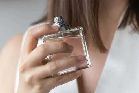 Kobieta testuje perfumy, szukając idealnego zapachu dla siebie. Elegancka buteleczka w dłoni.